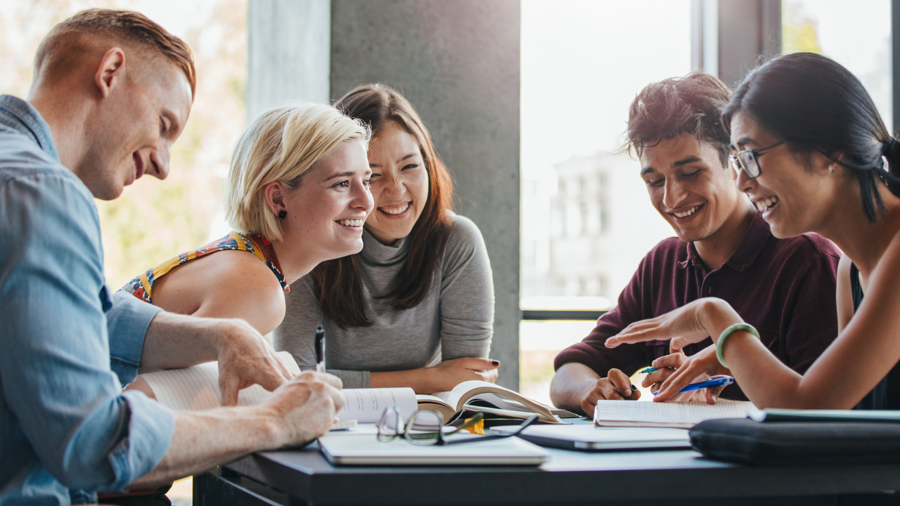 Studenter samtalar runt bord