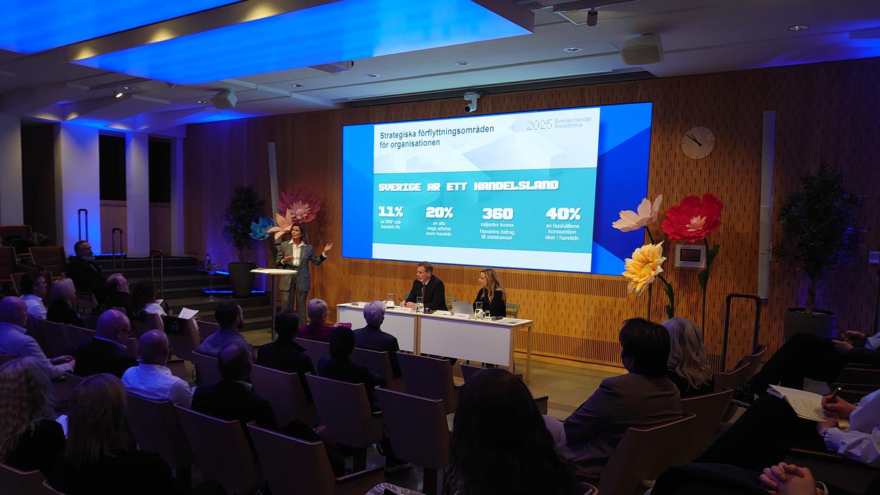 En grupp människor som sitter i stolar framför en projektorduk.