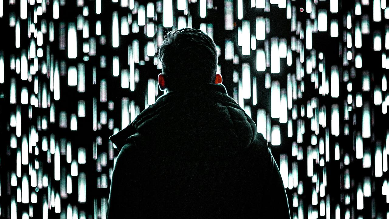 En man som står framför en vägg av ljus.