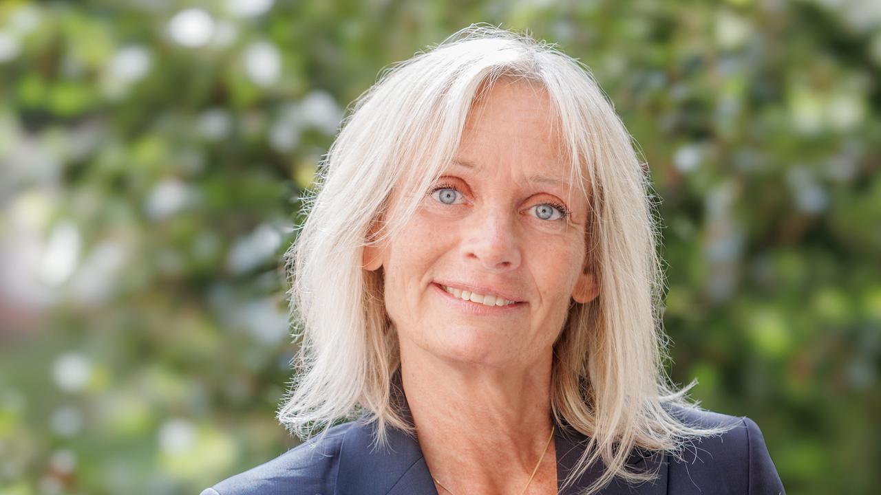 En kvinna i blå kavaj och skjorta.