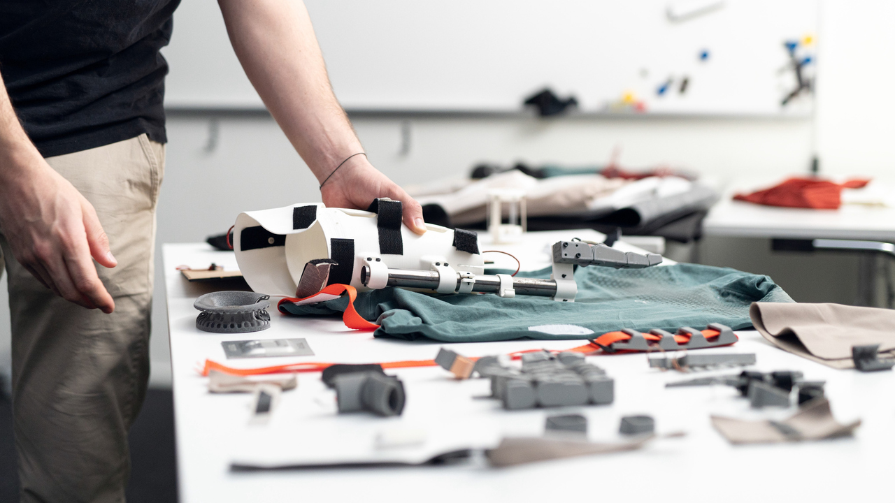 Närbild av en person som håller i en protes på ett bord.