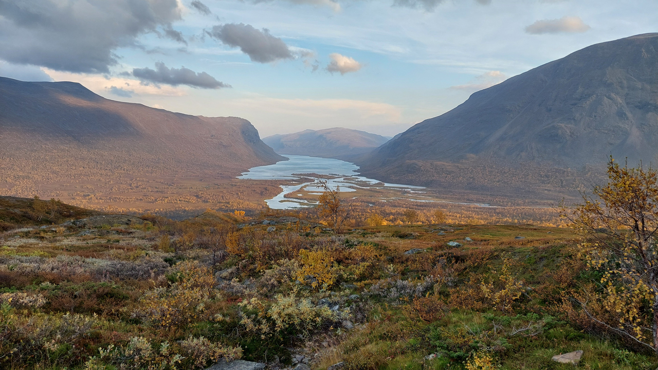Vy över vattendrag genom fjällandskap.