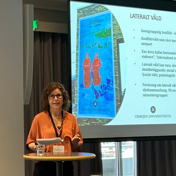 En kvinna står framför en projektionsskärm.