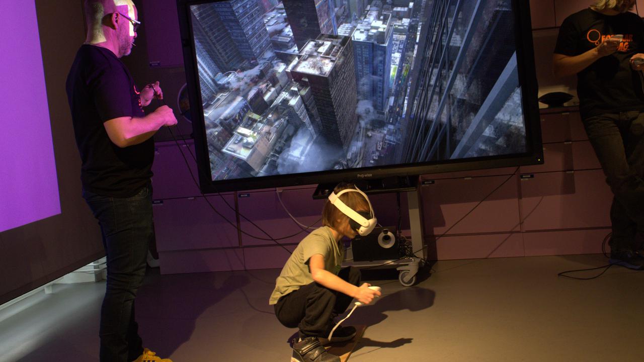 En person som sitter på huk med VR-set framför en tv.