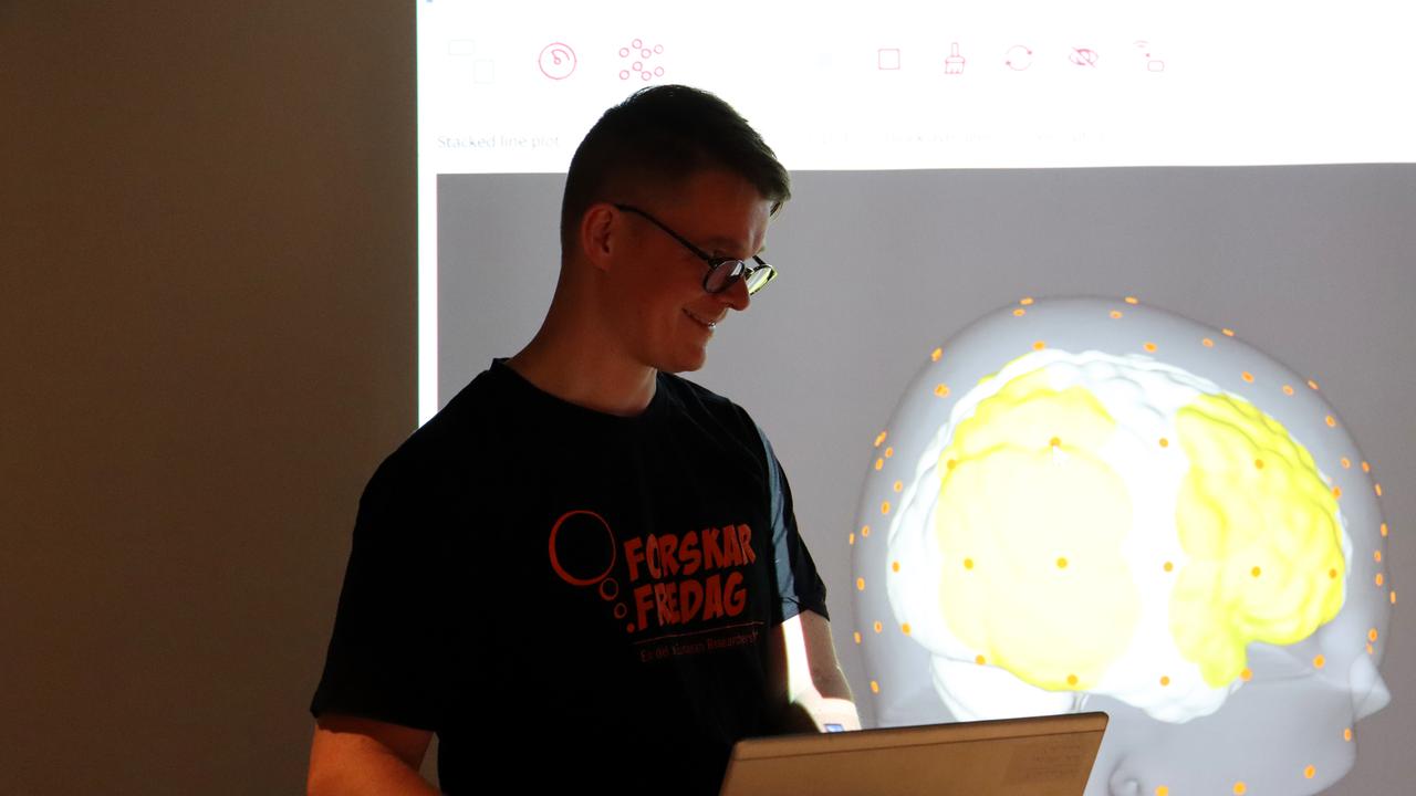 En man står framför en bärbar dator.