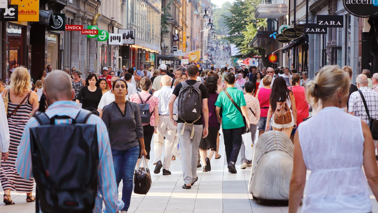Sommardag på gågatan Drottninggatan mellan Mäster Samuelsgatan och Kungsgatan i Stockholm, Sverige, med folk i rörelse.