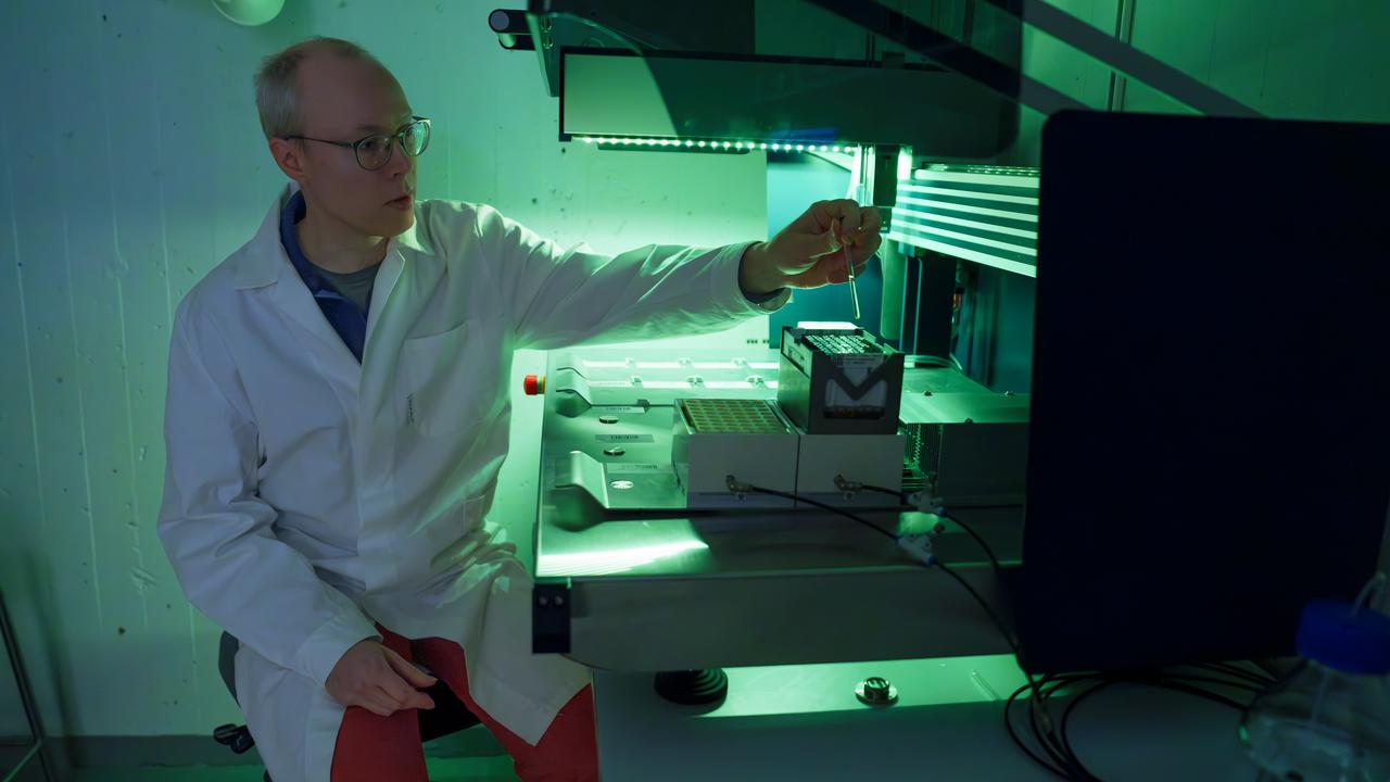 a person working in a laboratory with green light.