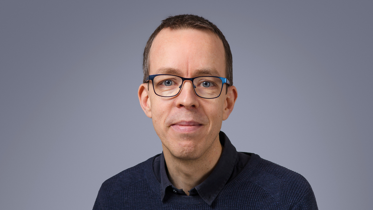 En man med glasögon poserar för en bild