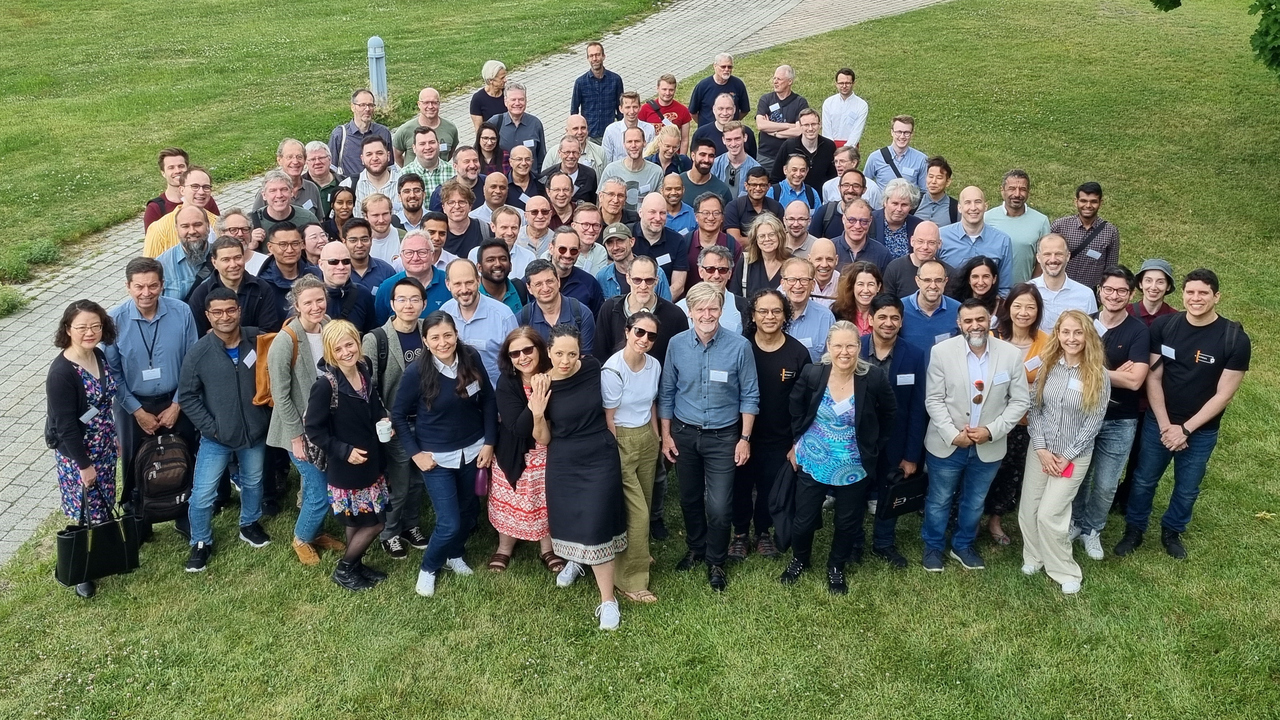 Bilden visar ett stort antal människor på en gräsmatta. De deltar i den 17e konferensen om distribuerade system, det vi kallar molnet. Med på bilden finns bland annat Erik Elmroth, professor i datavetenskap.