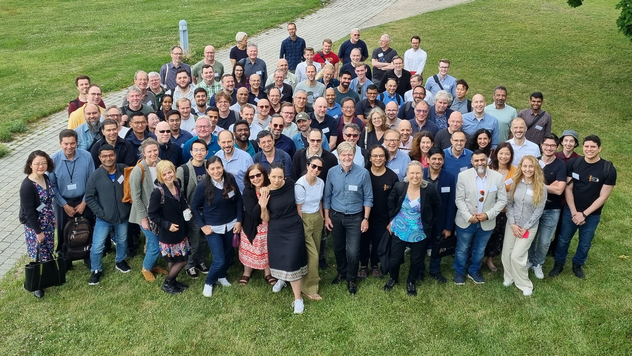 Bilden visar ett stort antal människor på en gräsmatta. De deltar i den 17e konferensen om distribuerade system, det vi kallar molnet. Med på bilden finns bland annat Erik Elmroth, professor i datavetenskap.