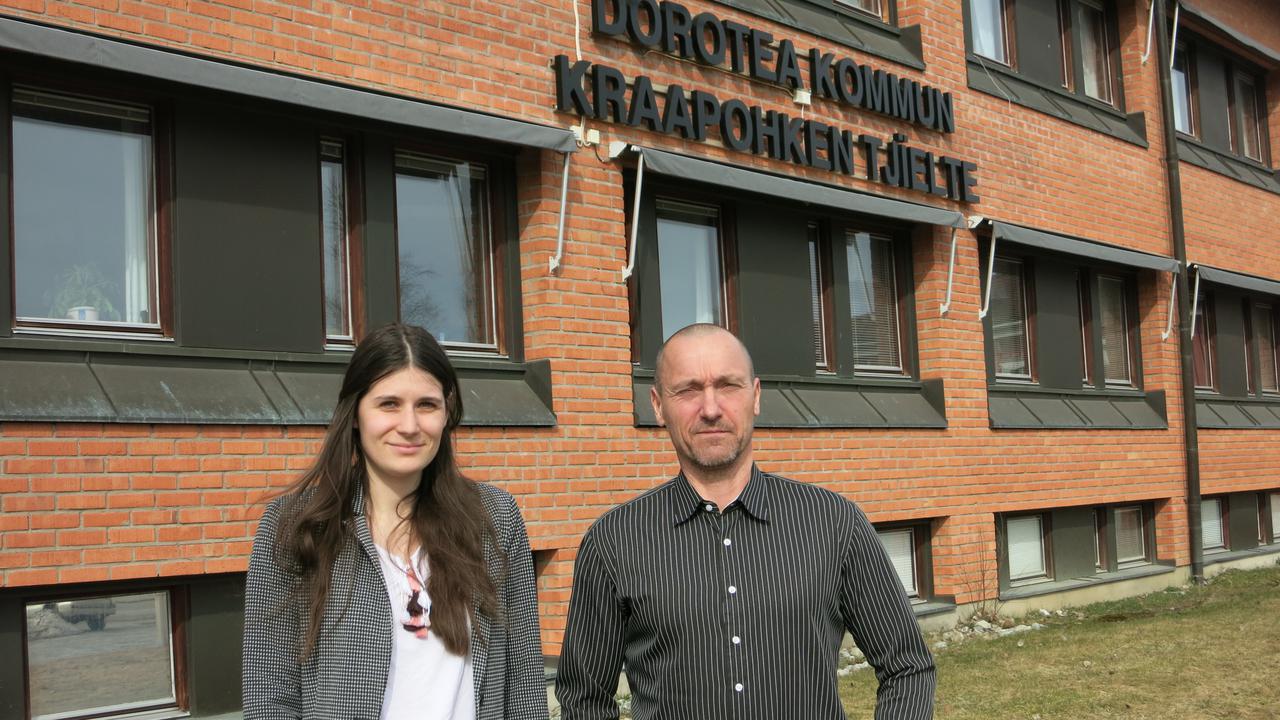 En man och en kvinna står framför en byggnad.