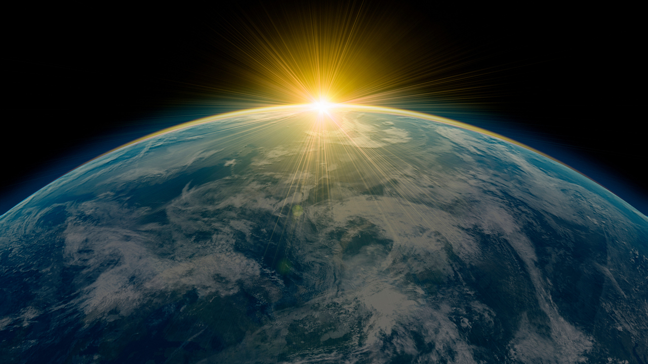 Del av jordklot med solen vid horisonten.