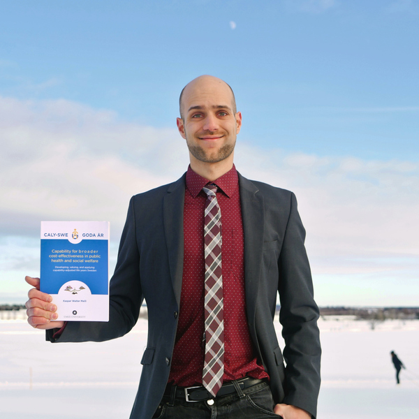 Porträttbild på Kaspar Meili, Institutionen för epidemiologi och global hälsa, som står i vintermiljö och håller i sin avhandling.