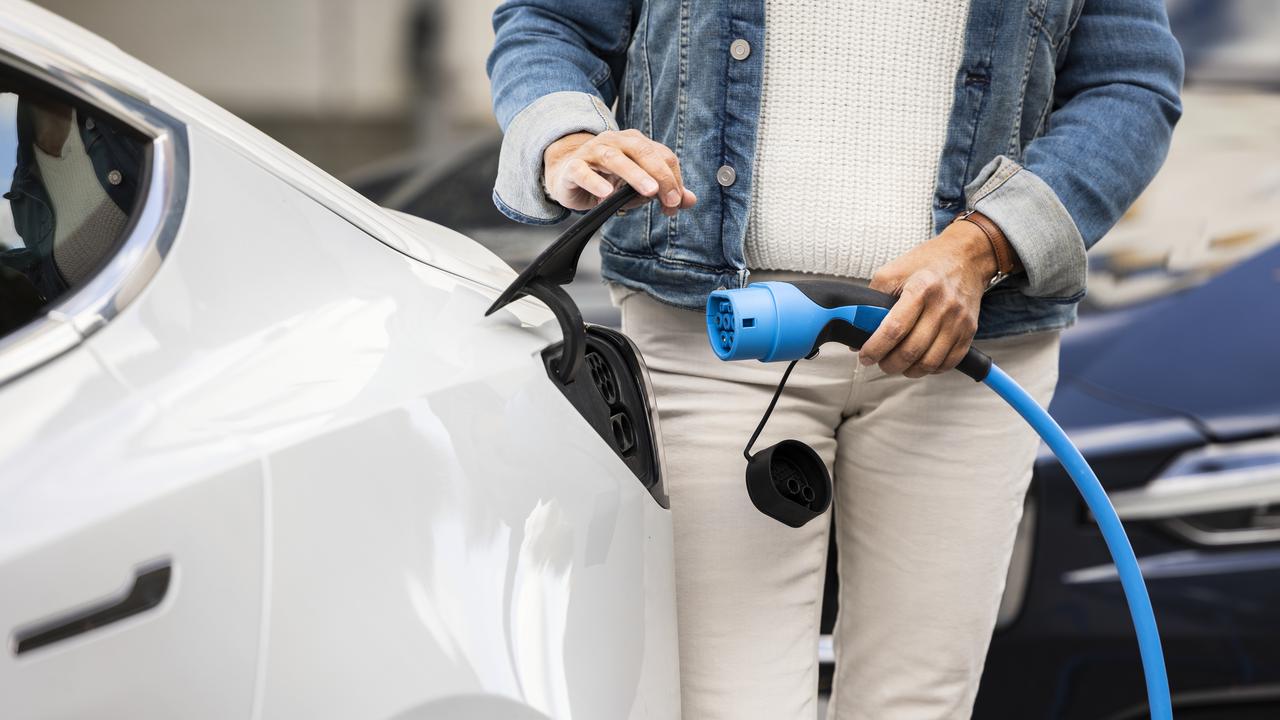 Bild på kvinna som sätter i kontakt för att ladda en elbil