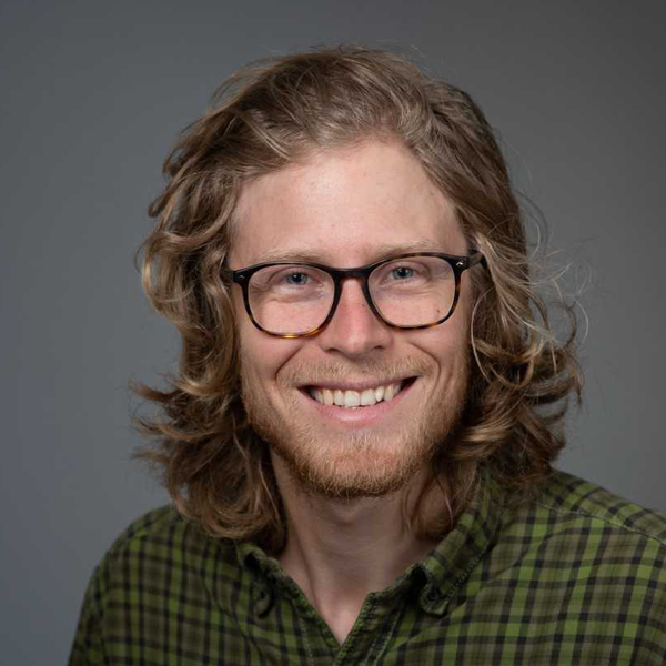 Glad man i glasögon.