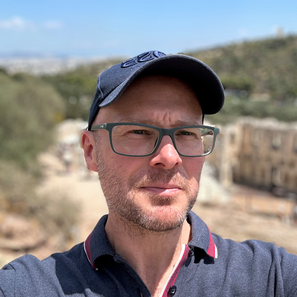 En man med glasögon och keps.