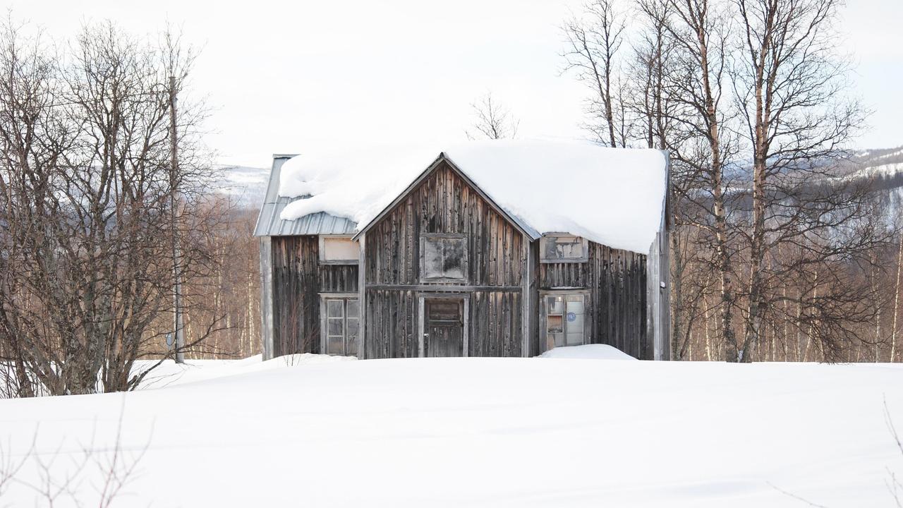 Övergivet tvåvåningshus i trä i fjällmiljö