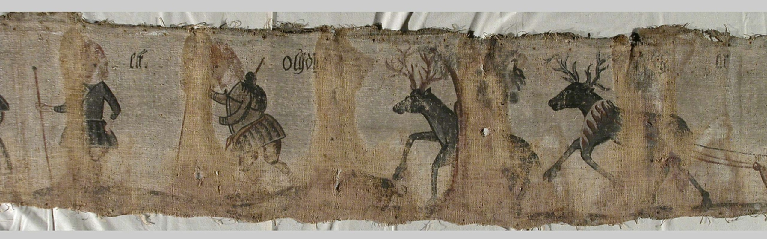 Ett tygstycke med bilder av människor och djur på.