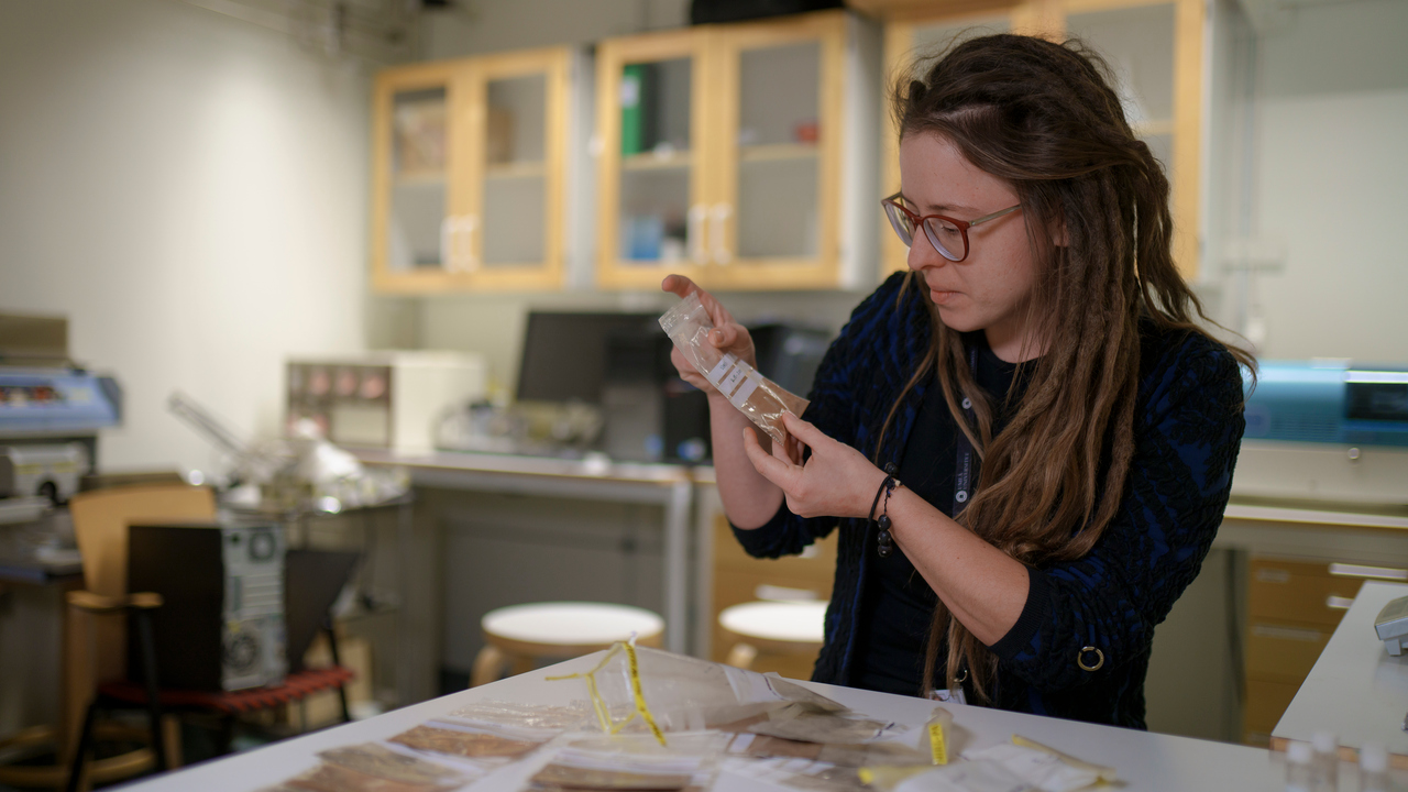 Václava Hazuková håller i en påse med grårött innehåll. 