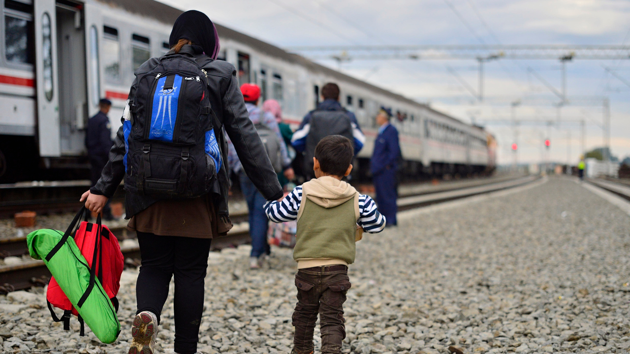 Kroatisk polis assisterar flyktingar som stiger på tåg i Tovarnik, Kroatien på väg mot Ungern i oktober 2015.