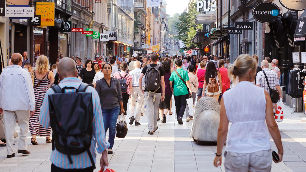 Sommardag på gågatan Drottninggatan mellan Mäster Samuelsgatan och Kungsgatan i Stockholm, Sverige, med folk i rörelse.