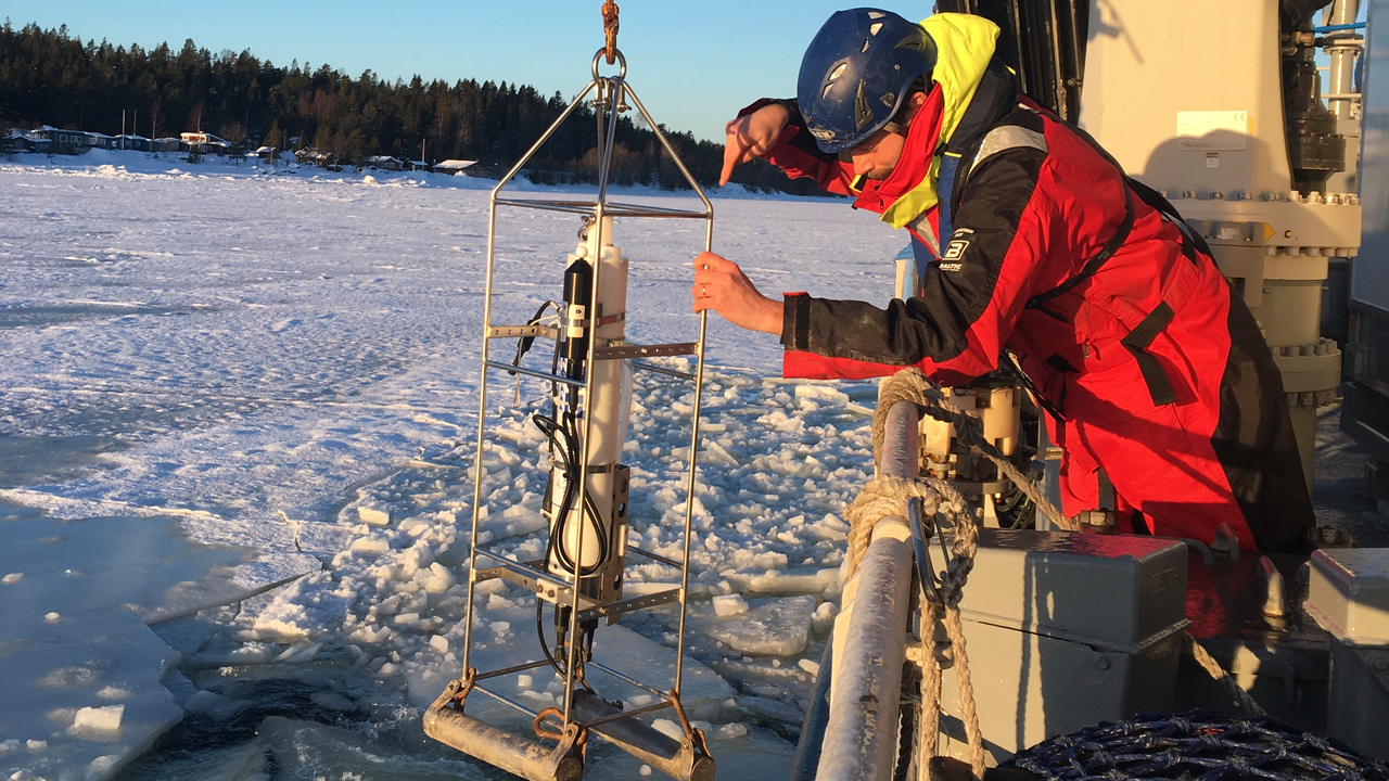 en person hanterar provtagningsutrustning vid relingen av ett fartyg