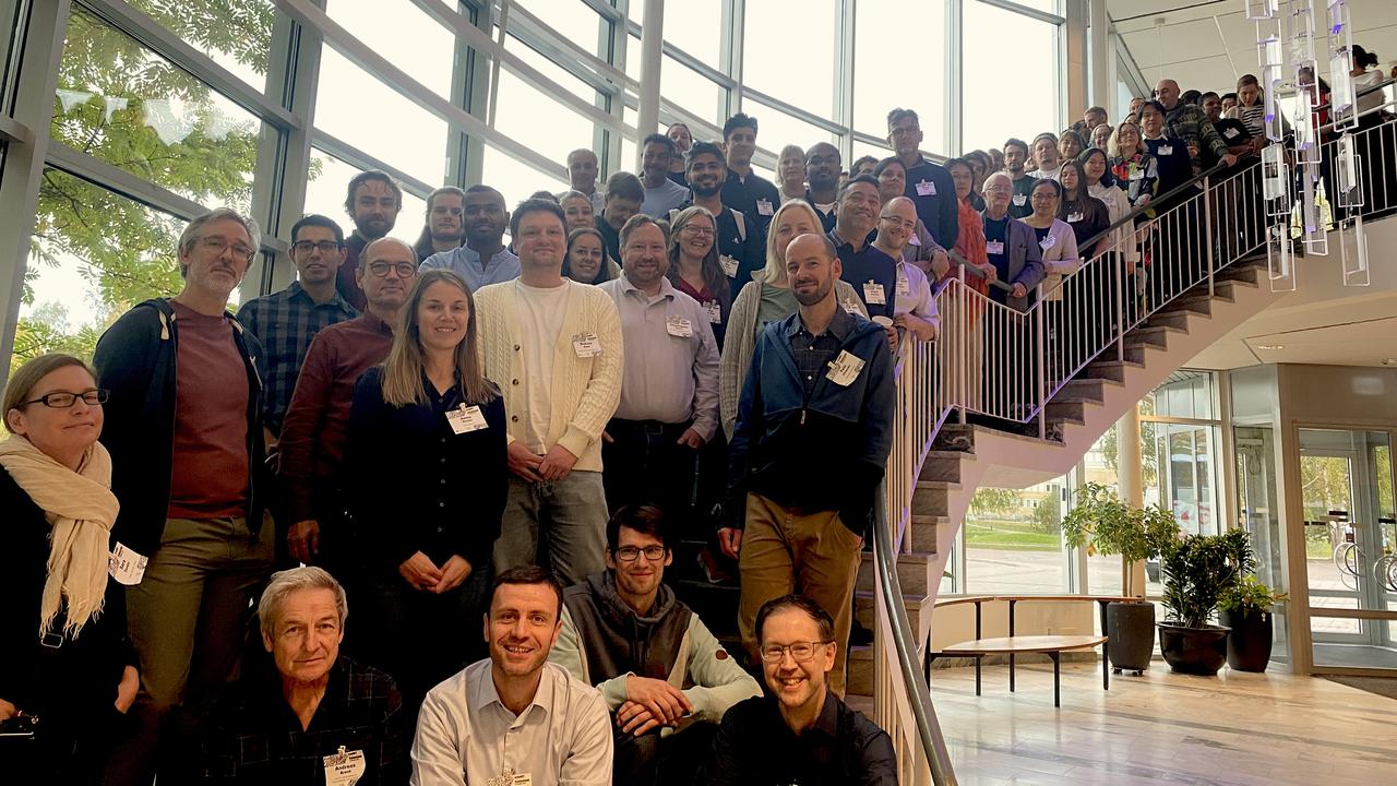 A group of people standing in front of a staircase taken at Umeå University during the cryoNET Symposium 2025