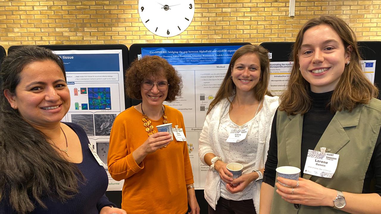 A group of women standing next to each other at the poster session of the scientific conference