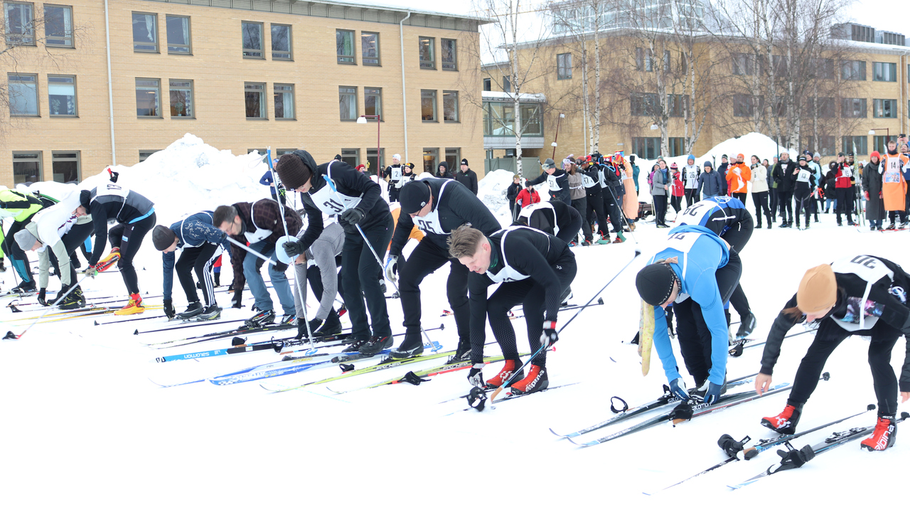 Participants of the skiing relay putting on their skis during the running start