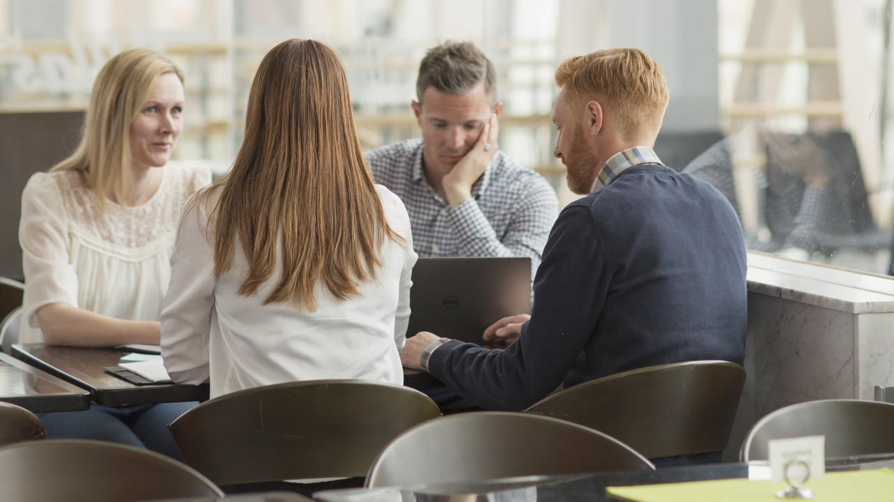 Människor sitter vid ett bord och samtalar.