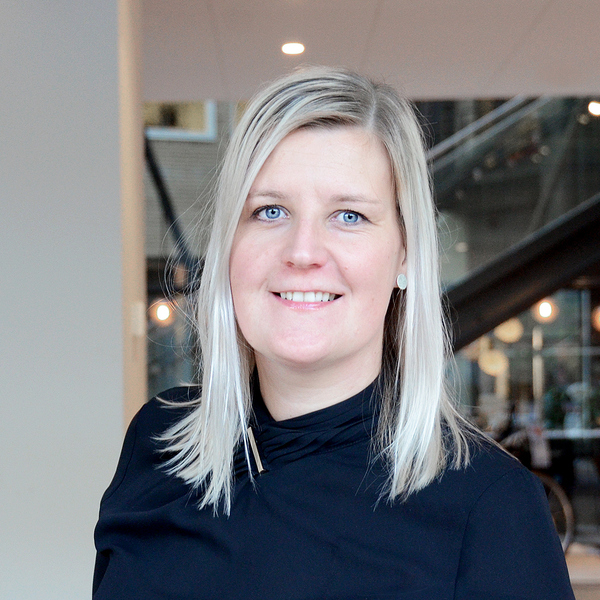 En kvinna i svart skjorta står i en lobby