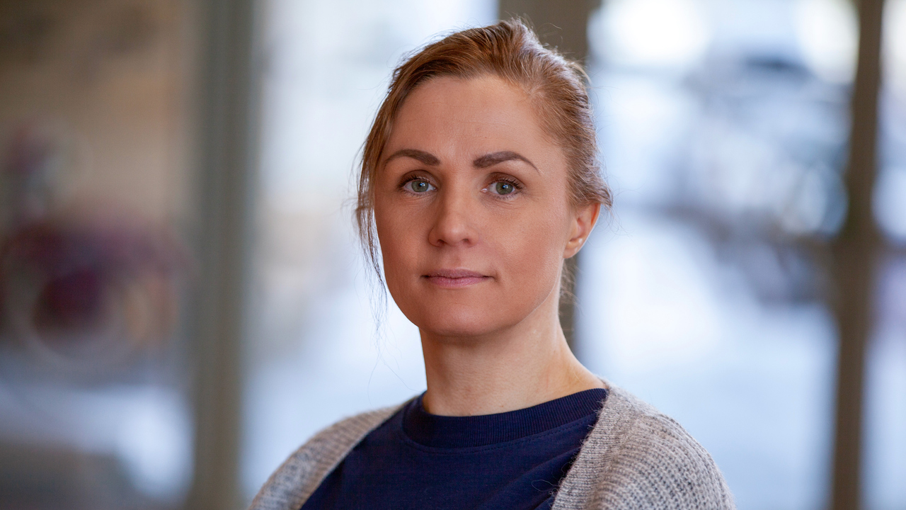 En kvinna står i en av universitetets byggnader.