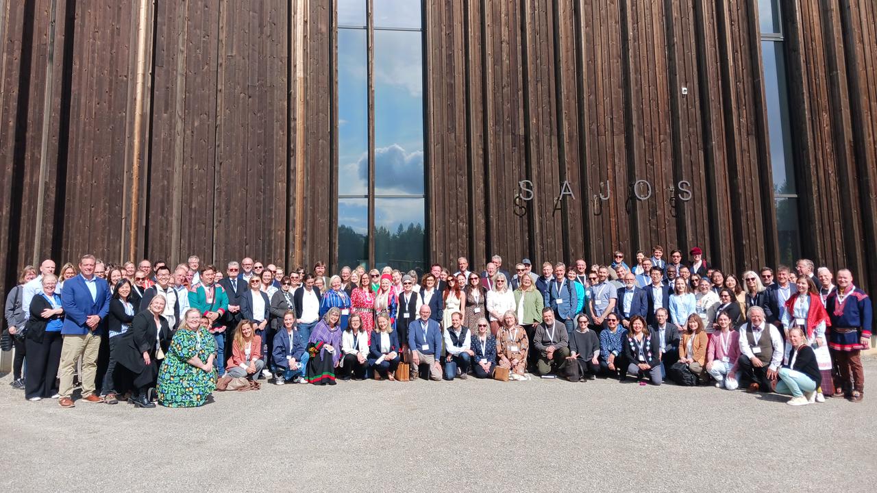 En grupp människor som står framför en byggnad.