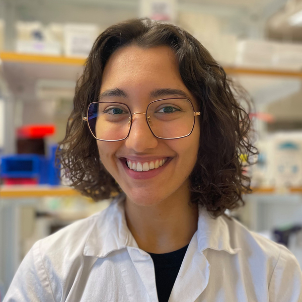 Portrait photo of Inés Hernandez Crego standing againt a background of shelves in the lab
