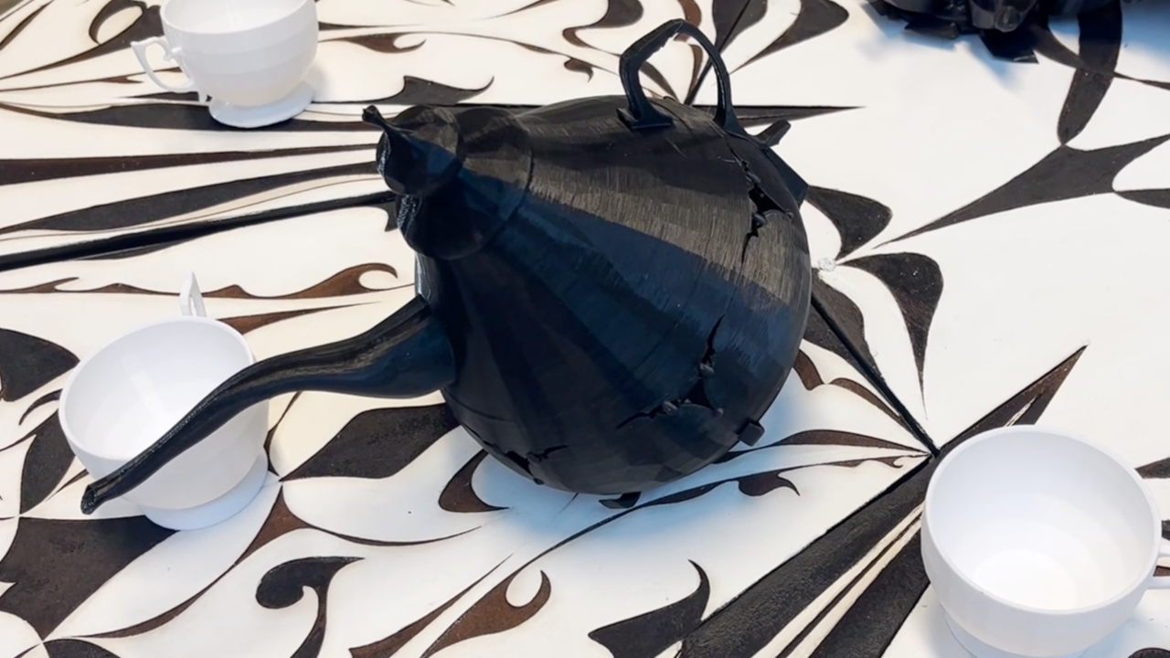 A black teapot sitting on top of a table