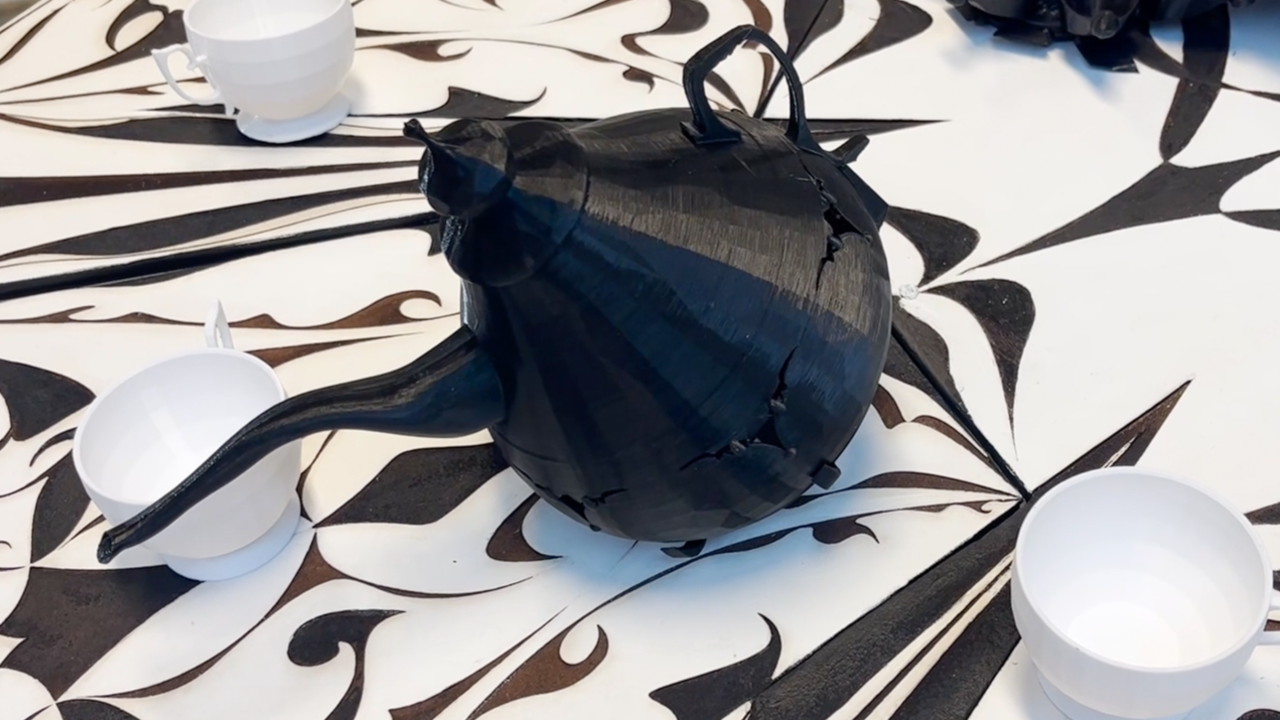A black teapot sitting on top of a table