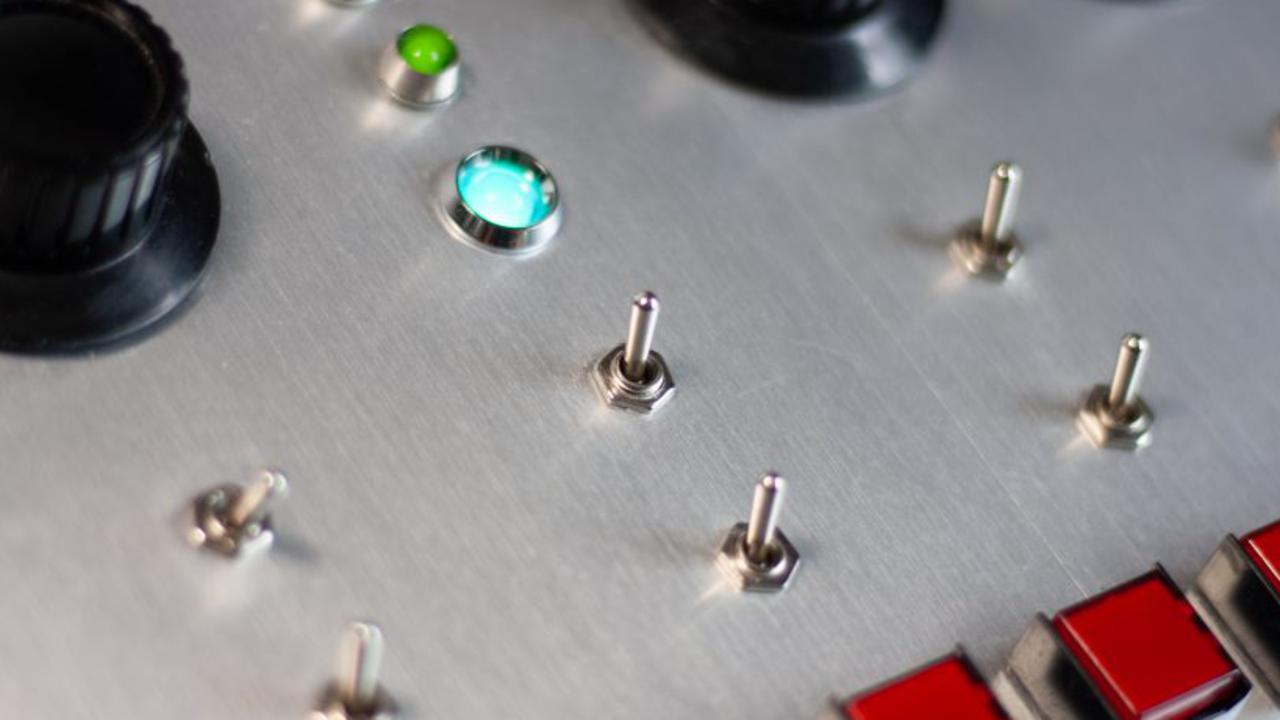 A close up of a control panel with buttons and knobs.