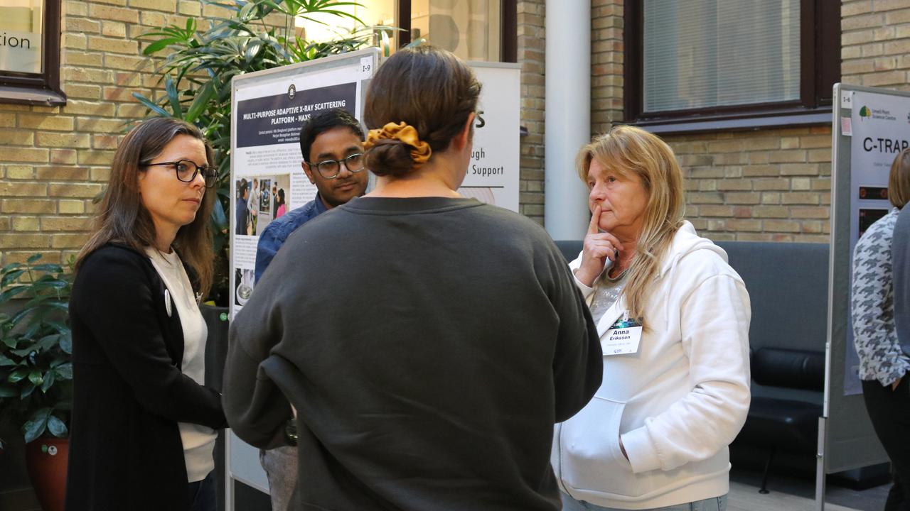 A group of people standing in front of posters during the scientific conference