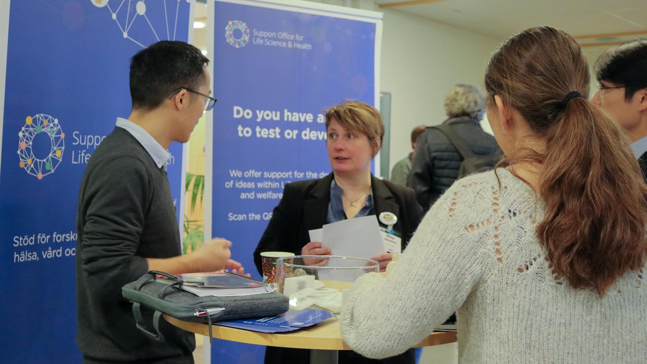 A group of people standing around a table.