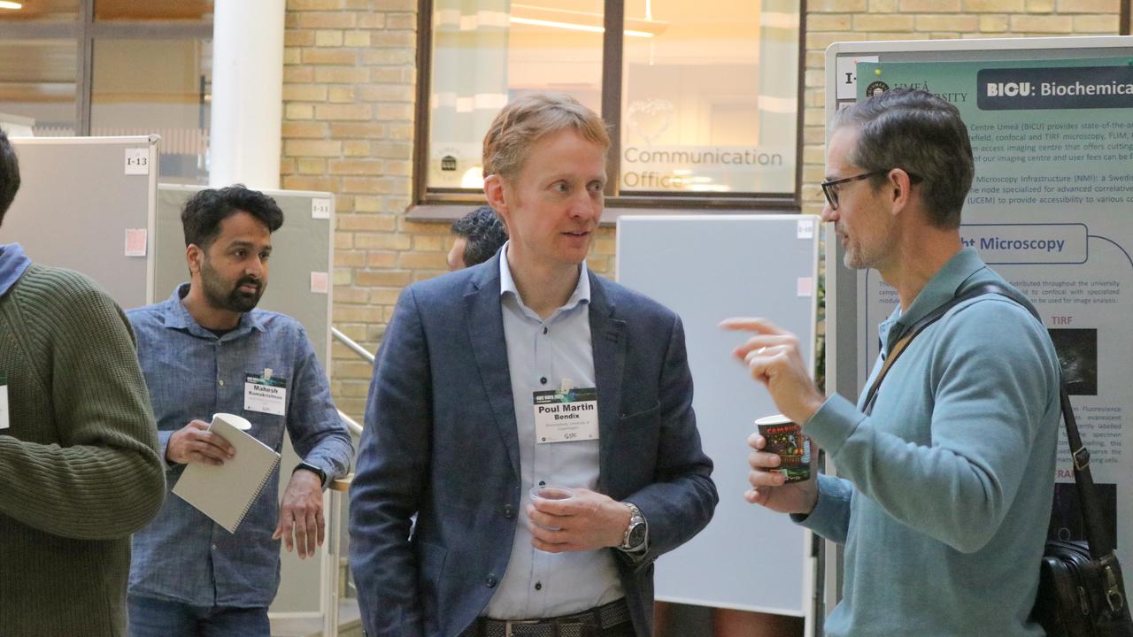 Two men in conversation during the poster session at the scientific conferenc
