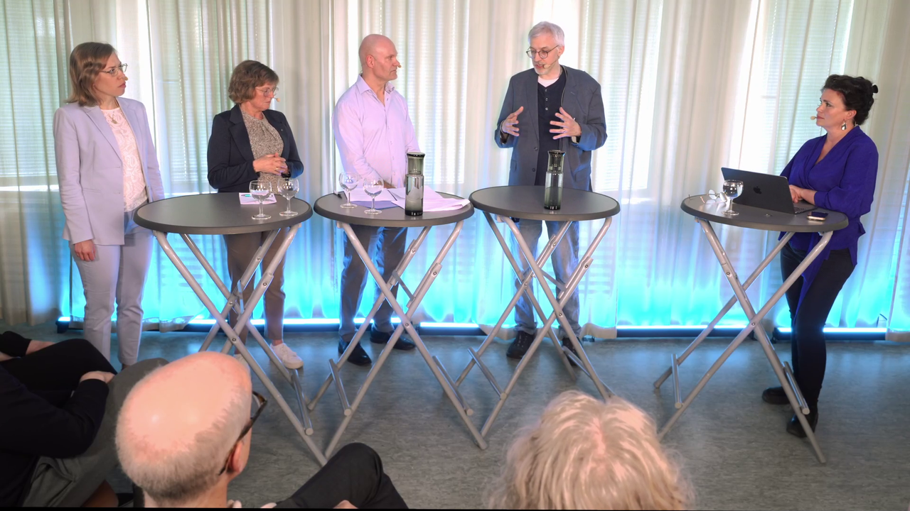 En grupp människor som står runt bord.