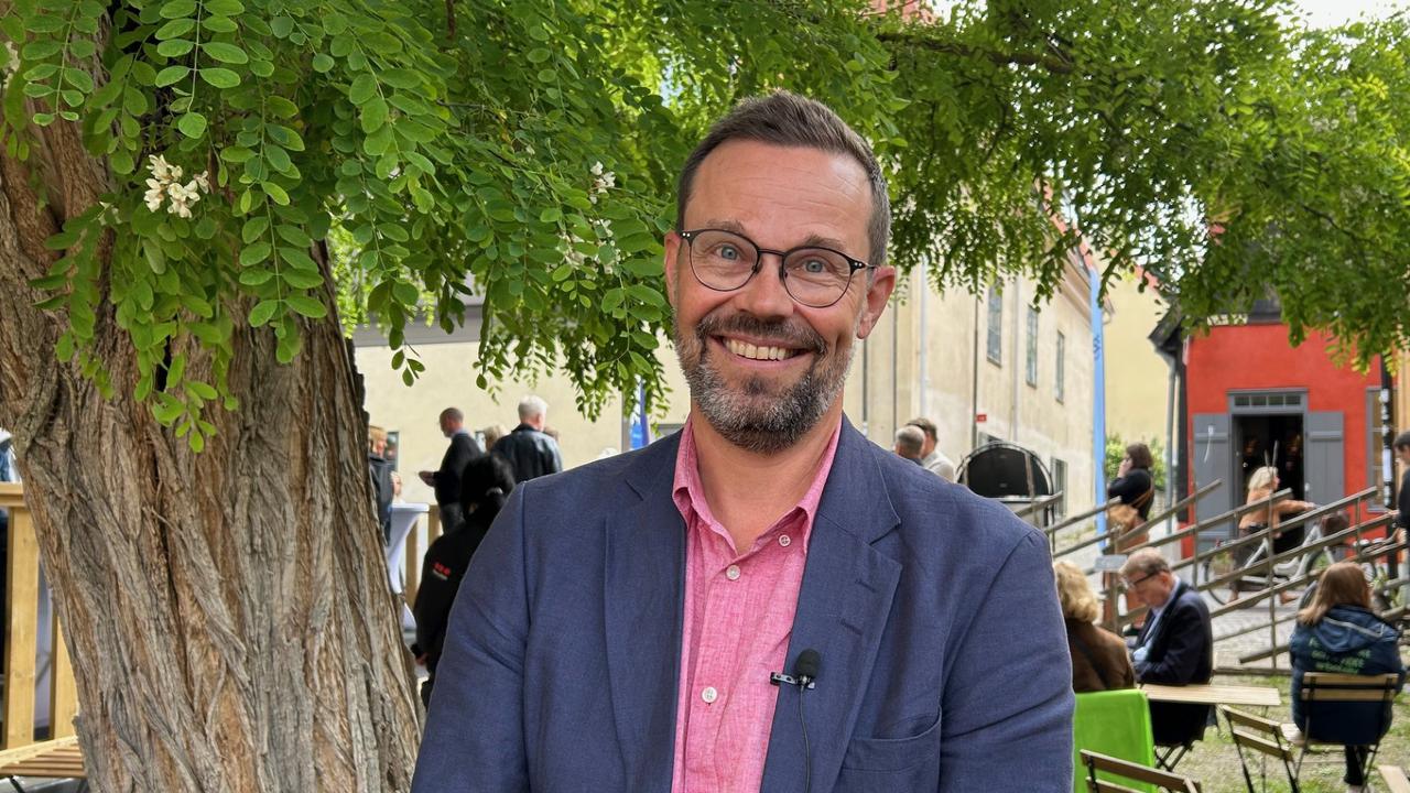 Man i kavaj framför träd. I Almedalen på Gotland.