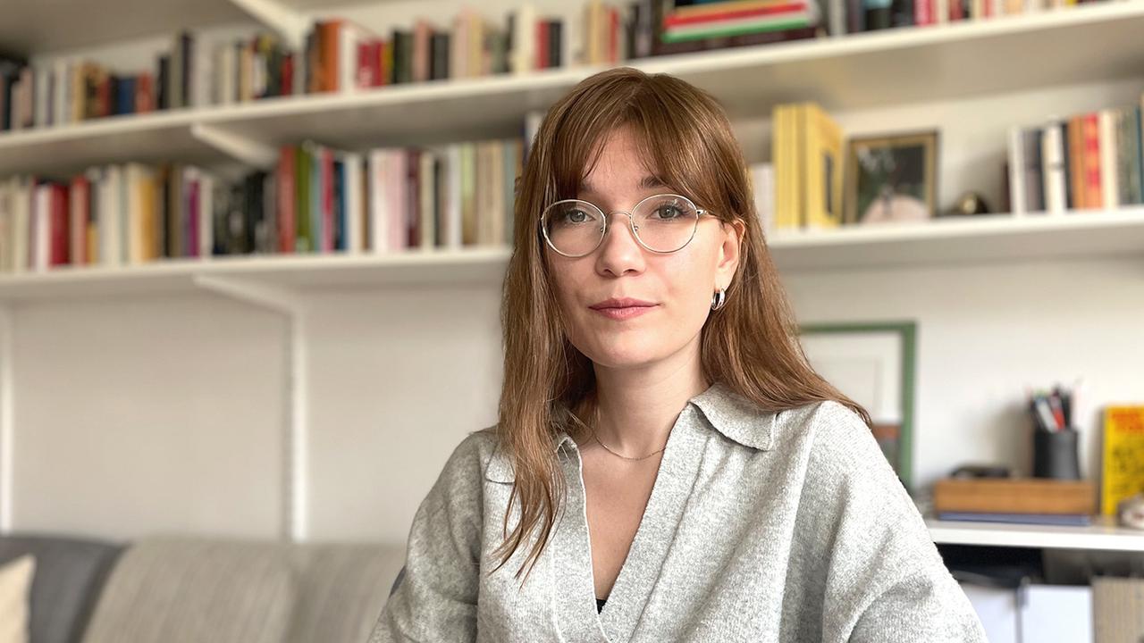 Anna Inez Bergman sitter framför en bokhylla