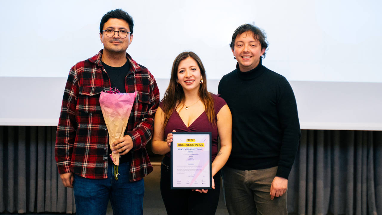 Tre personer som står bredvid varandra framför en projektorduk.