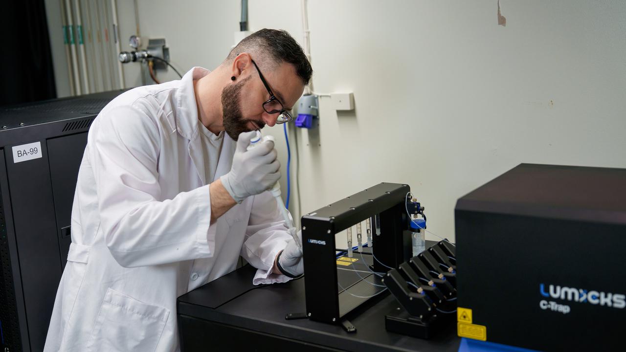 Rubén Casanova Sáez, klädd i vit labbrock och handskar, tillsätter något i en kapillär med hjälp av en pipett.