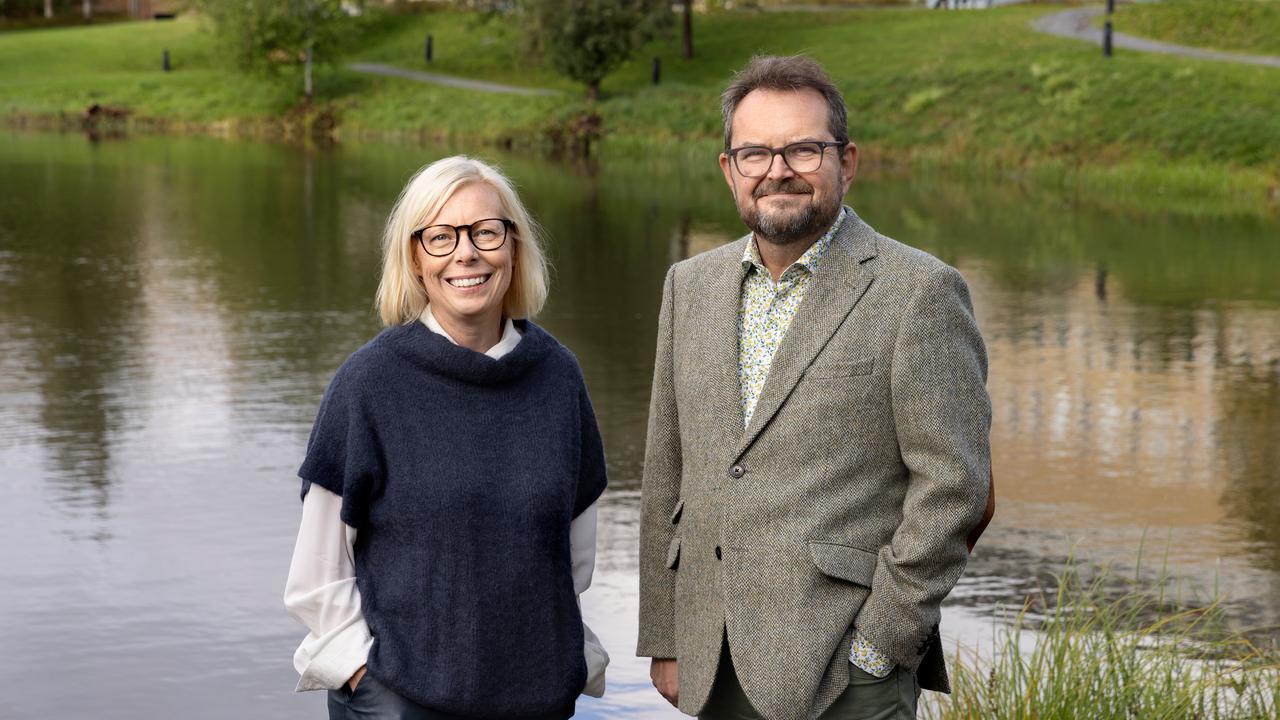 En man och en kvinna som står bredvid ett vattendrag.