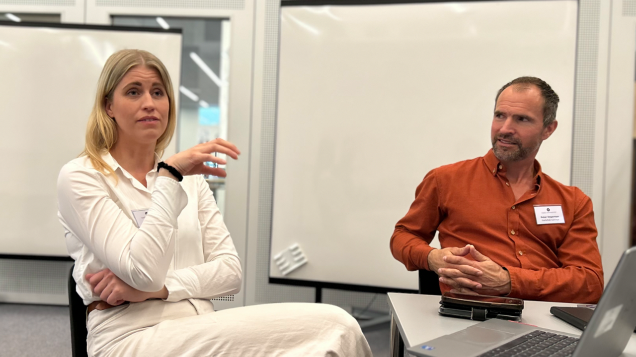 Kvinna pratar medan man tittar på.