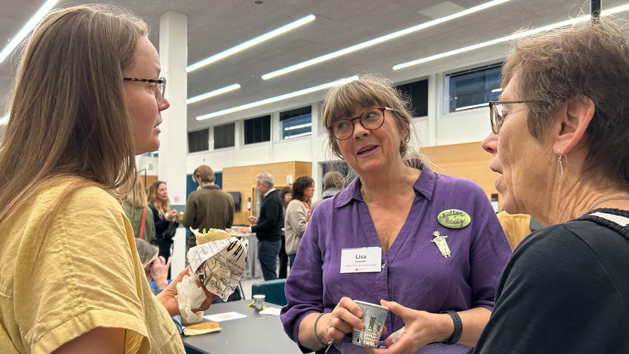 En grupp kvinnor som pratar med varandra i ett rum.