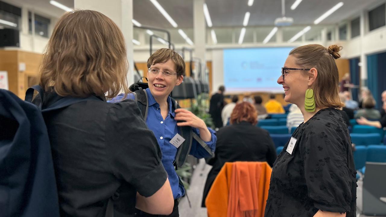 En grupp människor som pratar i en konferenslokal.