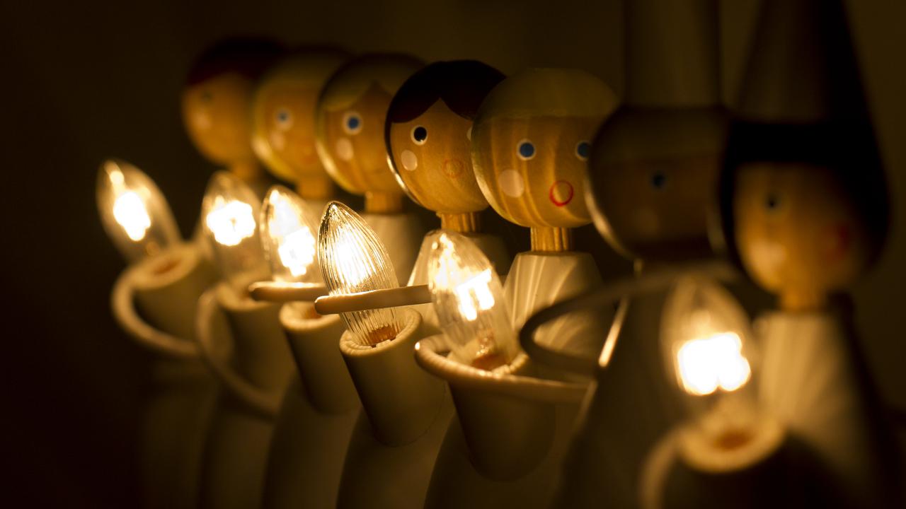 Adventsdekoration i form av trädockor med ljus som bildar luciatåg.